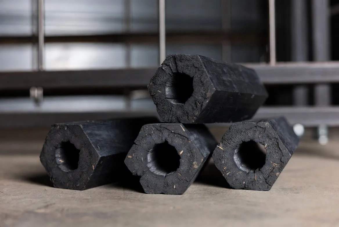 Hexagonal charcoal briquettes stacked in an industrial setting